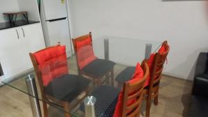 a table and chairs with red cushions in a room at Nice 2 bedroom apartment in Kelmscott