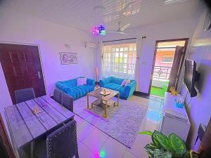 a living room with blue couches and a table at Homely Apt 2 with Aircon - ksh 500 in Kisumu