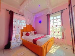 a bedroom with an orange bed in a pink room at Homely Apt 2 with Aircon - ksh 500 in Kisumu