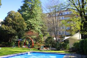a swimming pool with a hoop in front of a building at Hotel Greif, a Member of Design Hotels in Bolzano