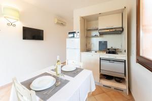 cocina con mesa y mesa blanca y sidx sidx de cocina en Apartments with shared pool Vignola Mare Aglientu, en Vignola Mare