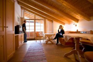 a woman sitting on a couch in a room with a man at Beim Nuihausa in Reit im Winkl