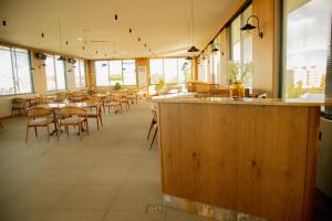 an empty restaurant with tables and chairs and windows at New Amaan Hotel in Zanzibar City