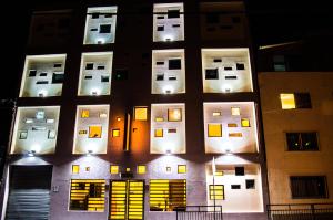 un edificio alto con ventanas iluminadas por la noche en Ayelen Express, en Calama