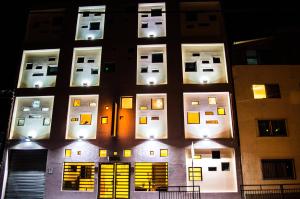 a tall building with lit up windows at night at Ayelen Express in Calama +19 photos