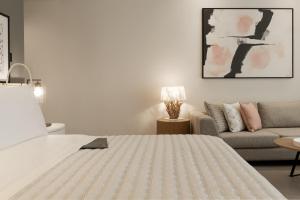 a white bedroom with a bed and a couch at Le Royal Meridien Beach Resort & Spa Dubai in Dubai