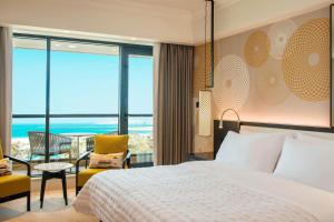 a bedroom with a bed and a view of the ocean at Le Royal Meridien Beach Resort & Spa Dubai in Dubai