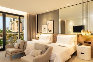 a hotel room with two beds and a tv at Le Royal Meridien Beach Resort & Spa Dubai in Dubai