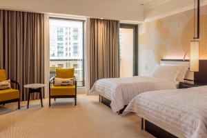 a hotel room with two beds and a window at Le Royal Meridien Beach Resort & Spa Dubai in Dubai