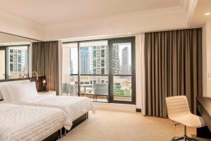 a hotel room with a bed and a large window at Le Royal Meridien Beach Resort & Spa Dubai in Dubai