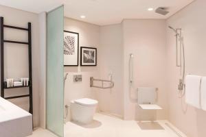 a bathroom with a toilet and a shower and a sink at Le Royal Meridien Beach Resort & Spa Dubai in Dubai