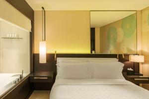a bedroom with a large bed and a mirror at Le Royal Meridien Beach Resort & Spa Dubai in Dubai
