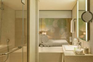 a bathroom with a shower and a sink and a mirror at Le Royal Meridien Beach Resort & Spa Dubai in Dubai