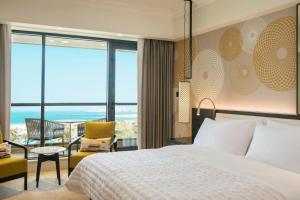 a bedroom with a bed and a view of the ocean at Le Royal Meridien Beach Resort & Spa Dubai in Dubai