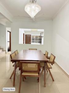 a dining room table with chairs and a chandelier at 5 Bedroom House Near Sunway Lagoon in Petaling Jaya +11 photos