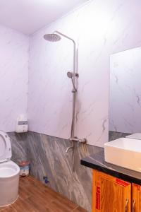 a shower in a bathroom with a toilet and a sink at Cherry homestay phòng đôi lớn in Buôn Ðũng