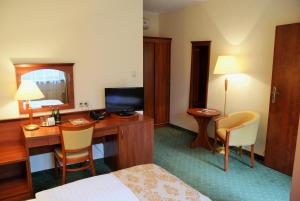 a hotel room with a desk and a bed at Gościniec Sucholeski in Suchy Las