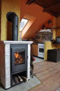 a fireplace in a kitchen with a stove at Chalupa Sonja in Lúčky