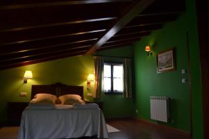 a bedroom with green walls and a bed with two pillows at La Fonte in Naves