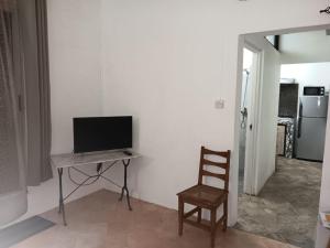 TV a/nebo společenská místnost v ubytování Studio Le Palmiste