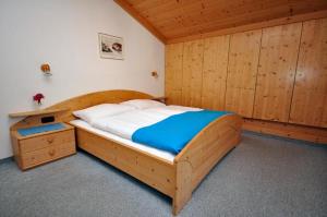 1 dormitorio con cama de madera y armario de madera en Appartements Familie Grundner, en Leogang
