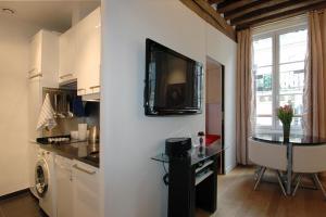 cocina con TV en una pared blanca en HolidaysInParis-Bourg Tibourg II, en París