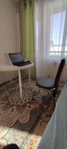 a bedroom with a desk and a laptop on a table at Квартира рядом с Караколом in Karakol