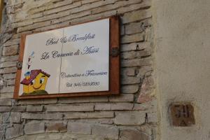 een bord aan de zijkant van een stenen muur bij B&B La Casuccia Di Assisi in Assisi
