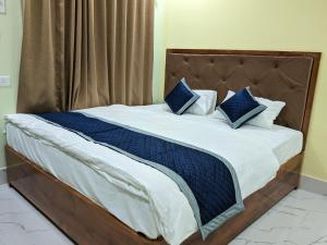 a bed with blue and white sheets and blue pillows at Grand brew inn in Hāsimāra