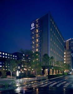 un bâtiment avec un panneau sur son côté la nuit dans l'établissement Hotel Gracery Tokyo Tamachi, à Tokyo