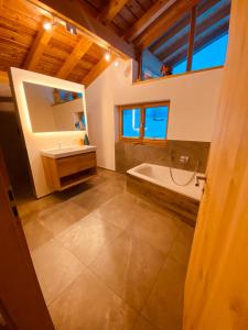 a bathroom with a tub and a sink and a mirror at Traumhaus sensationeller Lage Traumhafter Bergblick absolute Ruhe in Fischbachau