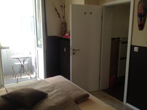 a bedroom with a bed and a table and a window at Hotel Sandmanns am Dom in Cologne