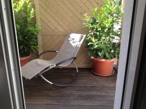 a chair sitting on a porch with plants at Hotel Sandmanns am Dom in Cologne