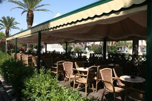 une rangée de tables et de chaises sous un auvent dans l'établissement Hotel Victoria, à Porto San Giorgio