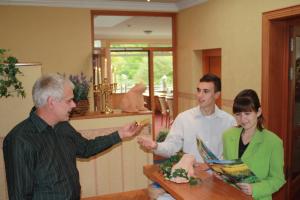 a group of three people standing around a table at Hotel Scholz in Hitzacker