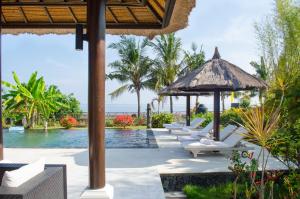 a pool at the resort with lounge chairs at Villa Danison in Umeanyar