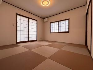 an empty room with two windows and a tiled floor at 満天の星空とBBQまるっと一棟貸切コテージ最大12名sora in Nasu-yumoto