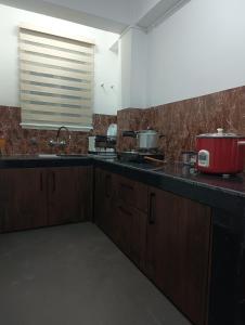 a kitchen with a counter top with a red appliance at Tersha Homestay 2BHK in Shillong