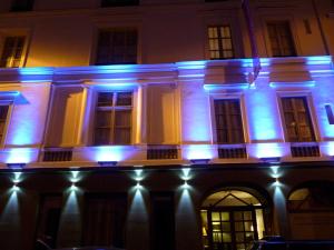 a building lit up at night with blue lights at ZE Hotel in Paris