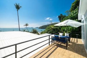 a patio with an umbrella and a table and chairs at 哦先生的海景别墅 Aoyon Beach in Phuket Town