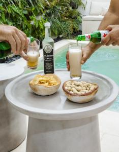 a person pouring a glass of milk and a plate of food at Bali Escapes- Studio And 1 Bedroom Villa in Uluwatu
