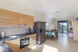 a kitchen with a stainless steel refrigerator and a living room at Almyrida Bay View House V BY APOKORONAS-VILLAS in Almirida