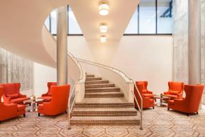 a staircase in a building with orange chairs at Sheraton Philadelphia University City Hotel in Philadelphia