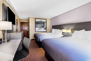 ein Hotelzimmer mit zwei Betten und einem Schreibtisch in der Unterkunft Super 8 by Wyndham Amsterdam in Amsterdam + 37 Fotos