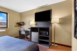 ein Hotelzimmer mit einem Bett und einem Schreibtisch mit Fernseher in der Unterkunft Super 8 by Wyndham Amsterdam in Amsterdam