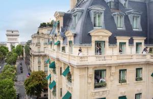 a large building with a large clock on top of it at Hotel The Peninsula Paris in Paris
