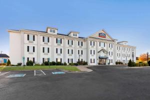 a large white building with a parking lot at Howard Johnson by Wyndham Jackson in Jackson