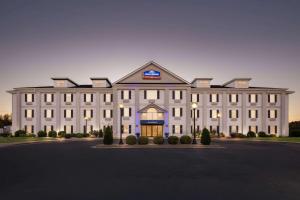 a large white building with a sign on it at Howard Johnson by Wyndham Jackson in Jackson