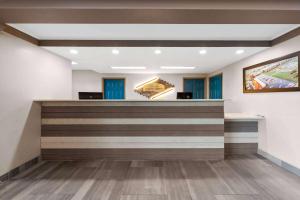 a lobby with a reception counter with blue doors at Howard Johnson by Wyndham Jackson in Jackson +37 photos