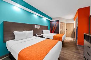 a hotel room with two beds and a television at Howard Johnson by Wyndham Jackson in Jackson